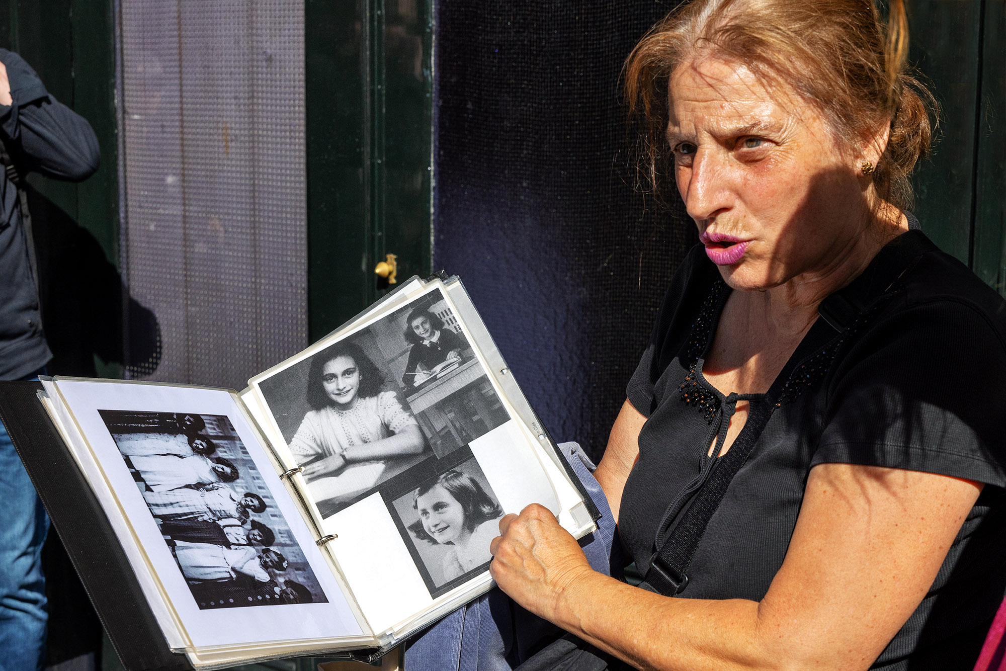 Stadtführerin zeigt historische Fotografien von Anne Frank